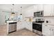 Bright kitchen with stainless steel appliances, white cabinetry, and a view to the dining area at 334 Bluebonnet Dr, Salisbury, NC 28146