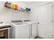 Functional laundry room with modern washer and dryer units, and storage shelves at 334 Bluebonnet Dr, Salisbury, NC 28146