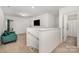 Bright loft area featuring neutral carpeting, a cozy green sofa, and an open doorway to a bathroom at 334 Bluebonnet Dr, Salisbury, NC 28146