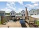 The backyard wooden deck features outdoor seating, a grill, and an umbrella for shaded relaxation at 334 Bluebonnet Dr, Salisbury, NC 28146