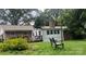 Backyard with brick exterior, deck, and a charming bench surrounded by lush greenery at 3378 Tanglewood Dr, Rock Hill, SC 29732