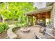 Beautiful backyard features a fire pit, covered patio, mature trees, and lush landscaping at 349 Miners Cove Way, Fort Mill, SC 29708