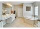 Bright bathroom with double vanity, soaking tub, and tiled floors at 349 Miners Cove Way, Fort Mill, SC 29708