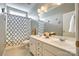 Well-lit bathroom featuring a double sink vanity, a large mirror and a shower with a patterned curtain at 349 Miners Cove Way, Fort Mill, SC 29708
