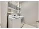 Modern laundry room equipped with a front load washer, dryer, and built-in shelving for storage at 349 Miners Cove Way, Fort Mill, SC 29708