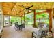 Inviting covered patio with a dining area, grill, ceiling fans, and lush green landscaping at 349 Miners Cove Way, Fort Mill, SC 29708
