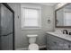 Updated bathroom featuring a shower with glass doors, a toilet, and a vanity with a gray cabinet at 3755 11Th Ne St, Hickory, NC 28601