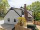 Back exterior of a two-story home, showcasing a wood deck, brick chimney, and fenced yard at 3755 11Th Ne St, Hickory, NC 28601