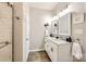 A renovated bathroom featuring dual sinks, shaker cabinets, and wood flooring at 3939 Archer Notch Ln, Huntersville, NC 28078