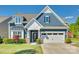 Charming two-story home with a well-manicured lawn, attached garage, and beautiful blue siding at 4083 Home Grown Way, Clover, SC 29710