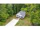 Aerial view of home with long driveway, surrounded by lush trees at 409 Woodcrest Ln, Albemarle, NC 28001