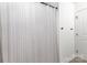 Bathroom showcasing white shower curtain with vertical stripes and neutral walls for a clean and minimalist design at 409 Woodcrest Ln, Albemarle, NC 28001