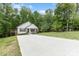 Charming home featuring a well-manicured lawn, long concrete driveway, and inviting front porch with a wooded backdrop at 409 Woodcrest Ln, Albemarle, NC 28001
