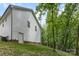 Side view of home backing to mature trees and sloping lawn at 409 Woodcrest Ln, Albemarle, NC 28001