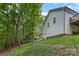 Side view of home backing to mature trees and sloping lawn at 409 Woodcrest Ln, Albemarle, NC 28001