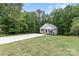 Charming home featuring a well-manicured lawn, long concrete driveway, and inviting front porch in a wooded setting at 409 Woodcrest Ln, Albemarle, NC 28001