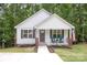 Inviting front exterior with white siding, shutters, a cozy front porch, and a walkway with landscape lighting at 409 Woodcrest Ln, Albemarle, NC 28001