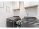 Modern laundry room with front-load washer and dryer plus convenient storage at 409 Woodcrest Ln, Albemarle, NC 28001