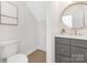 Charming half-bathroom features gray cabinets, a gold trimmed mirror, and neutral walls at 426 Walden Trl, Waxhaw, NC 28173