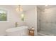Bathroom with a stand-alone tub, glass shower, and modern chandelier at 426 Walden Trl, Waxhaw, NC 28173