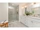 A bright bathroom featuring a frameless glass shower and double vanities at 426 Walden Trl, Waxhaw, NC 28173