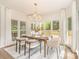 Dining room with hardwood floors, white curtains, large windows, elegant chandelier, and modern furnishings at 426 Walden Trl, Waxhaw, NC 28173
