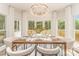 Dining room with a chandelier and large windows overlooking a wooden deck and lush greenery at 426 Walden Trl, Waxhaw, NC 28173