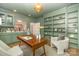 The home office boasts built-in shelving, stylish decor, and an open view to the kitchen at 426 Walden Trl, Waxhaw, NC 28173