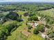 Lush landscape featuring a pond, mature trees, and various outbuildings at 4734 Polk Ford Rd, Stanfield, NC 28163