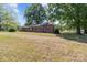 Quaint brick home on a spacious lot, surrounded by mature trees and a grassy lawn at 4734 Polk Ford Rd, Stanfield, NC 28163