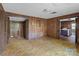 This expansive living room features wood paneling and entryways to the kitchen and bedroom, needs some TLC at 4734 Polk Ford Rd, Stanfield, NC 28163