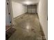 Unfinished basement space with concrete floor and garage door, offering potential for customization at 5012 Wheat Sw Dr, Concord, NC 28027