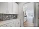 Well-lit kitchen featuring white cabinets, sleek countertops, and modern mosaic backsplash at 5027 Mclaughlin Loop # 61, Waxhaw, NC 28173