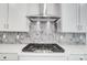 Close-up of a kitchen with stainless steel hood, chevron backsplash, and gas cooktop at 5027 Mclaughlin Loop # 61, Waxhaw, NC 28173