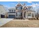 Charming two-story home with a stone facade and light gray siding, with an attached two-car garage at 5031 Mclaughlin Loop # 60, Waxhaw, NC 28173