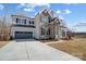 Handsome two-story home featuring a stone facade, neutral siding, dark shutters, and an attached two-car garage at 5031 Mclaughlin Loop # 60, Waxhaw, NC 28173