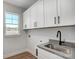 Laundry room boasts white cabinets, a utility sink, and a window at 5031 Mclaughlin Loop # 60, Waxhaw, NC 28173