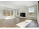 Sunlit living room boasts ample windows, recessed lighting, wood floors, and a modern fireplace at 5031 Mclaughlin Loop # 60, Waxhaw, NC 28173