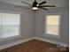 This is a bright bedroom with two windows, a ceiling fan, and neutral walls, offering a cozy and inviting space at 510 Belmont Mount Holly Rd, Belmont, NC 28012