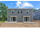 Exterior view of the back of a gray townhome, highlighting the patio and sliding glass door entries at 511 Bowman Rd, Charlotte, NC 28217