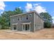 The back of the townhome features gray siding, a cozy patio, and sliding glass doors leading indoors at 511 Bowman Rd, Charlotte, NC 28217