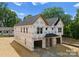 Exterior view of a new construction duplex with Tyvek wrap and attached garages against a blue sky backdrop at 511 Bowman Rd, Charlotte, NC 28217