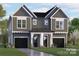 A modern duplex with gray siding, black garage doors and a covered entryway, with manicured landscaping at 511 Bowman Rd, Charlotte, NC 28217