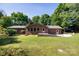 A brick home exterior is enhanced by a spacious backyard with a paved patio at 567 Willie Ln, York, SC 29745