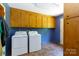 Laundry room boasts built in cabinets above a washer and dryer, with blue walls at 567 Willie Ln, York, SC 29745