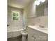 Bathroom featuring white fixtures, subway tile, and refinished hardwood floors at 589 Fork Rd, Norwood, NC 28128