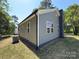 Rear quarter view of a gray-sided single-Gathering home with a brick chimney at 589 Fork Rd, Norwood, NC 28128