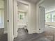 Hallway featuring an open doorway to a bathroom with white subway tile at 589 Fork Rd, Norwood, NC 28128