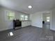 Bright and modern kitchen featuring white cabinets, gray floors, and stainless steel appliances at 589 Fork Rd, Norwood, NC 28128
