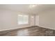 Bright living room features neutral paint, hardwood floors, a large window, and a front entry door at 592 Rambo E Rd, Rock Hill, SC 29730